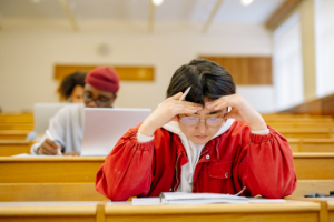 Man studying in red jacket.